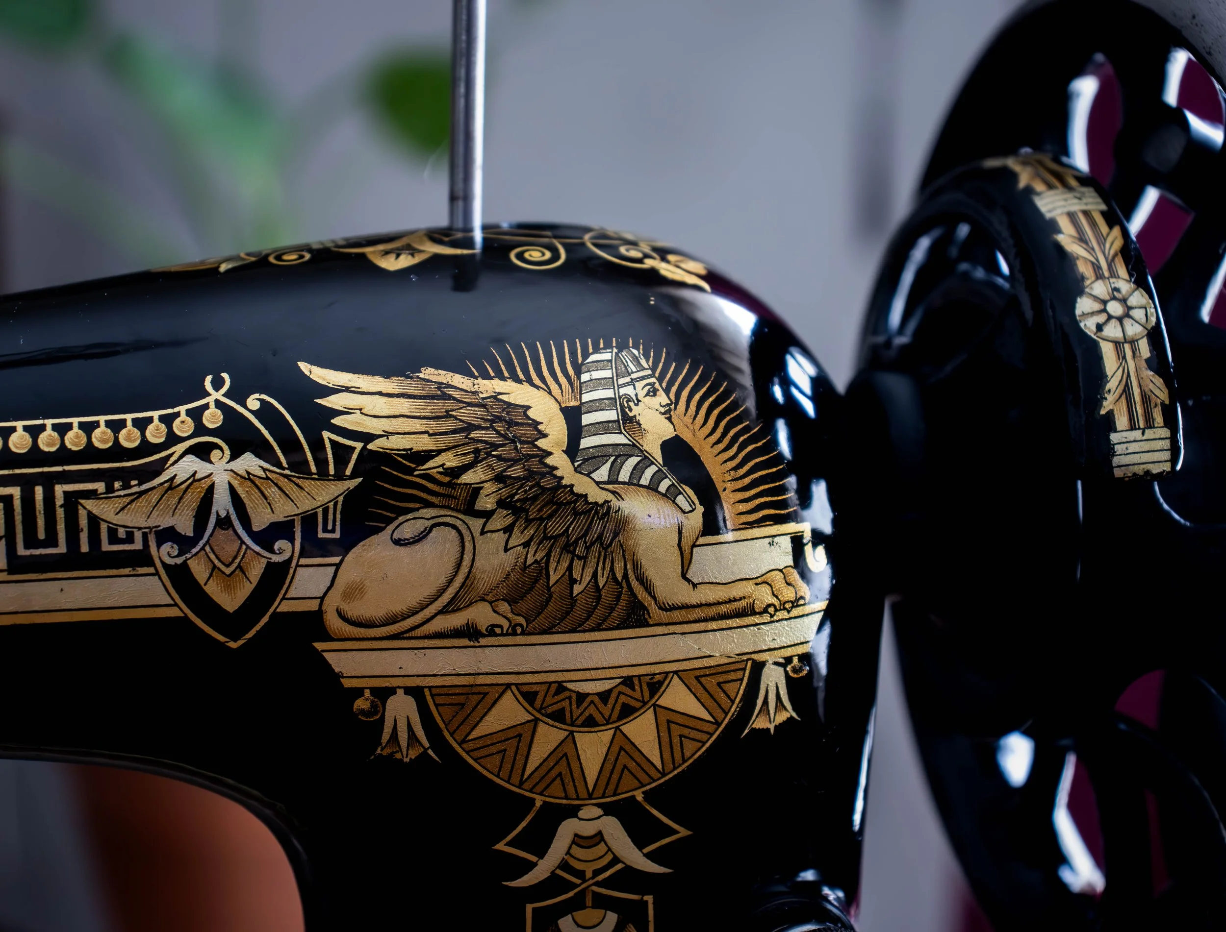 Détail d'une moto noire ornée de décorations dorées, notamment une écharpe avec un visage de femme et d'autres motifs élaborés.