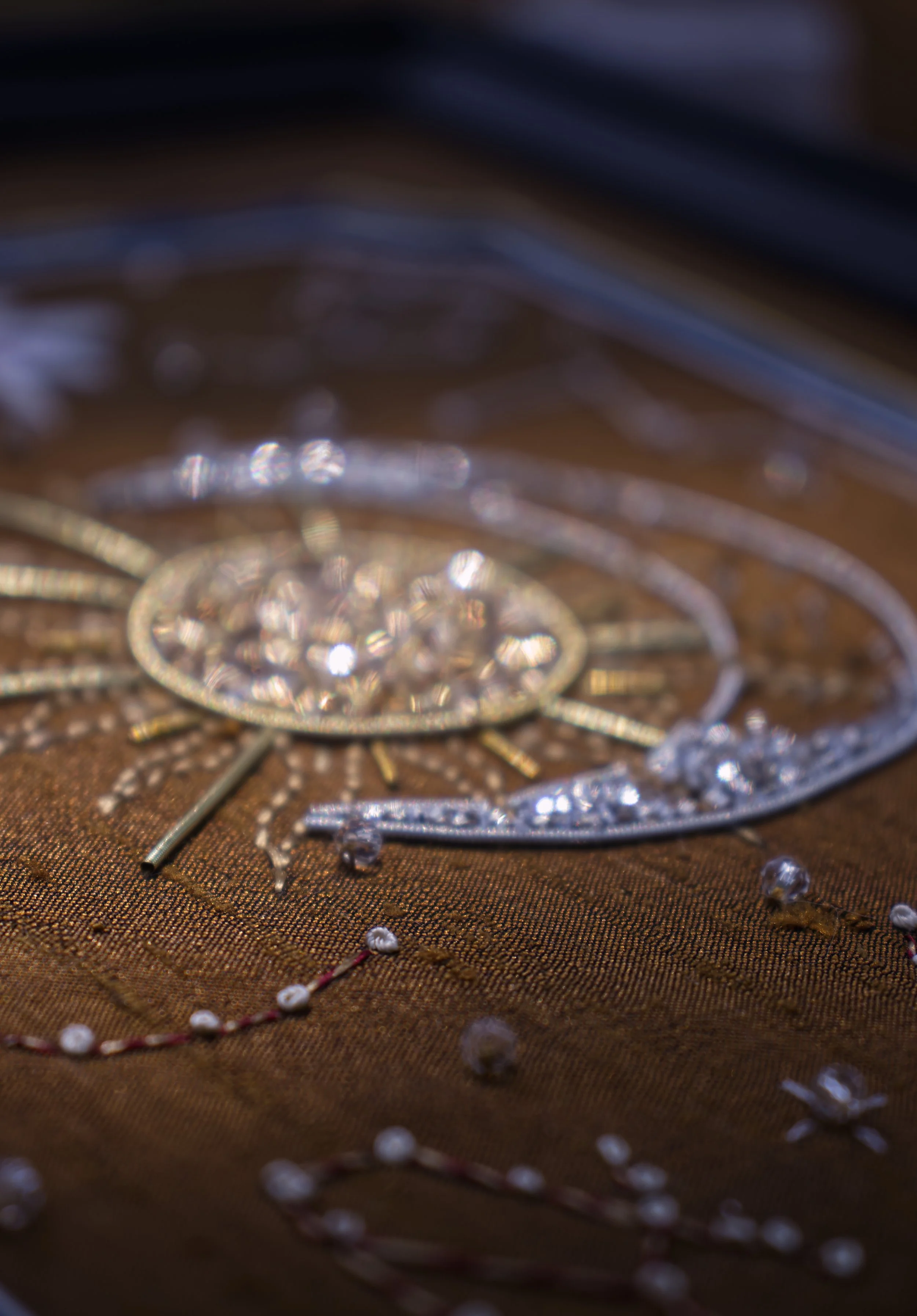 bijoux en argent, diamant, et perles, posé sur un tissu doré