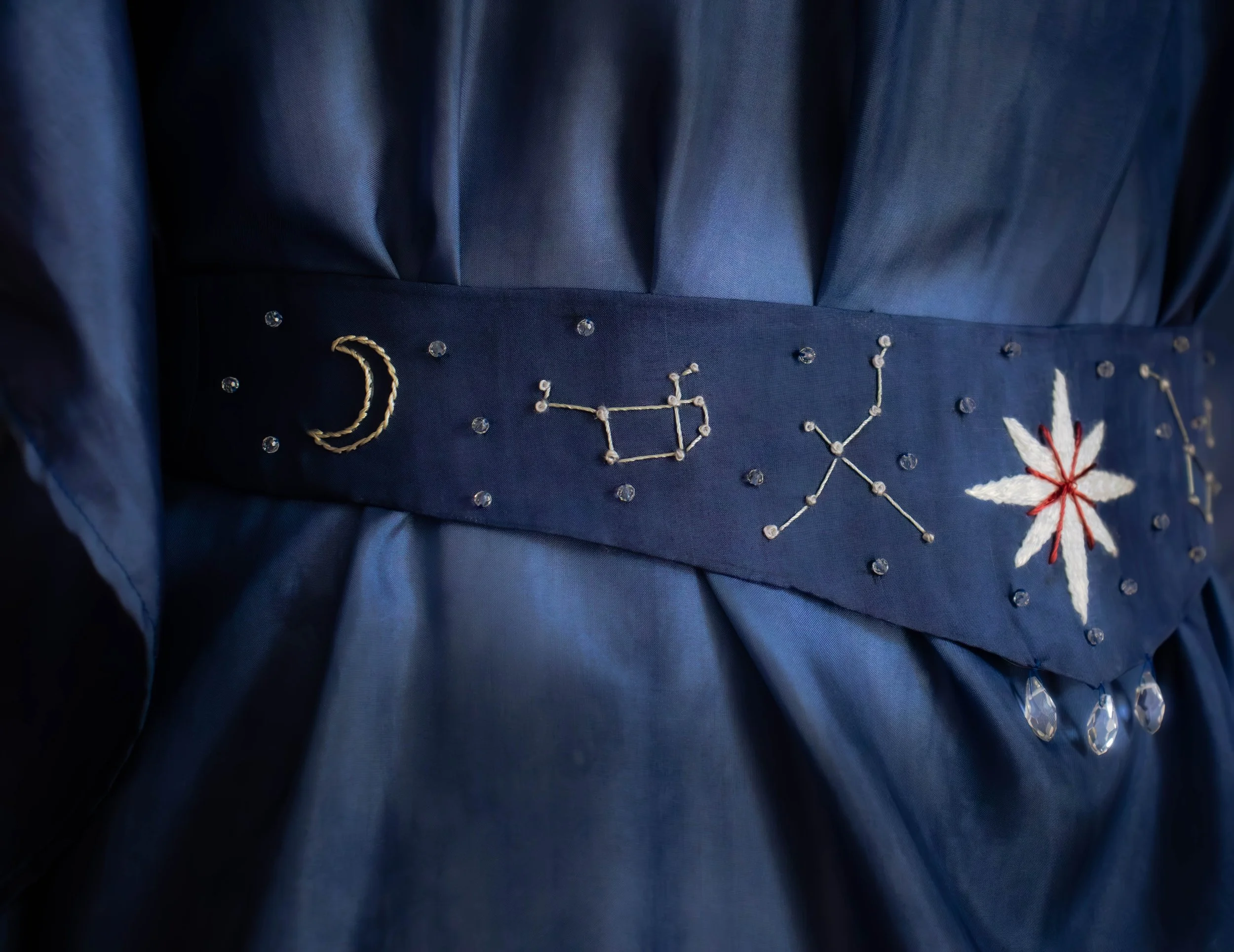 Cordon de fête bleu foncé avec des broderies argentées, étoiles de fil blanc et rouge.
