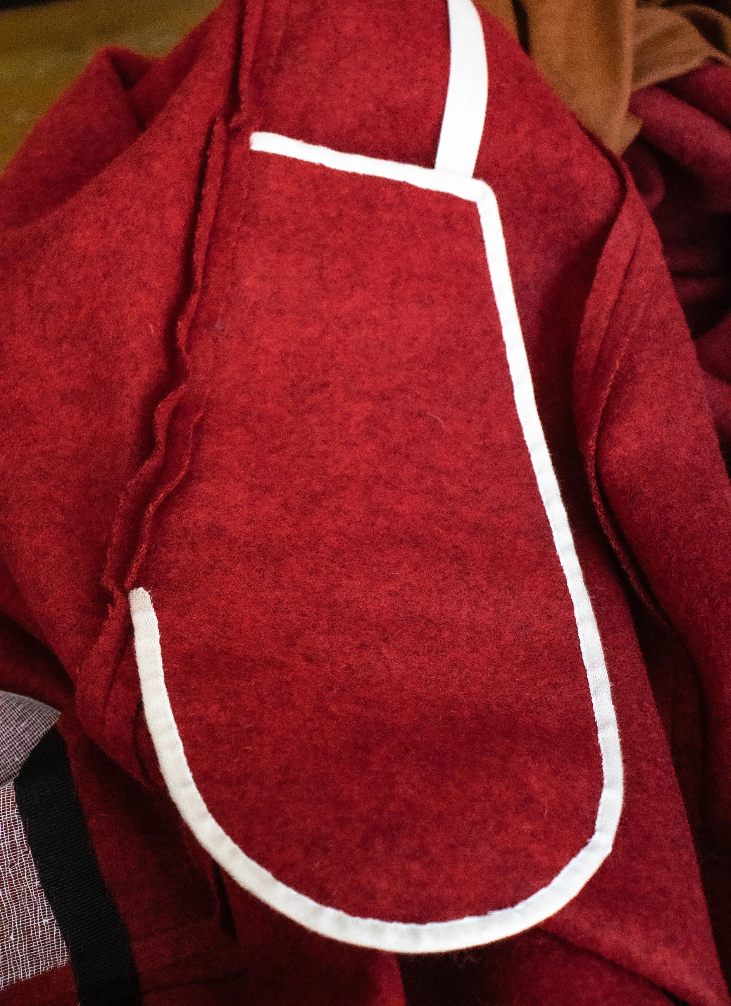 Veste rouge avec une bordure blanche, vue partielle.