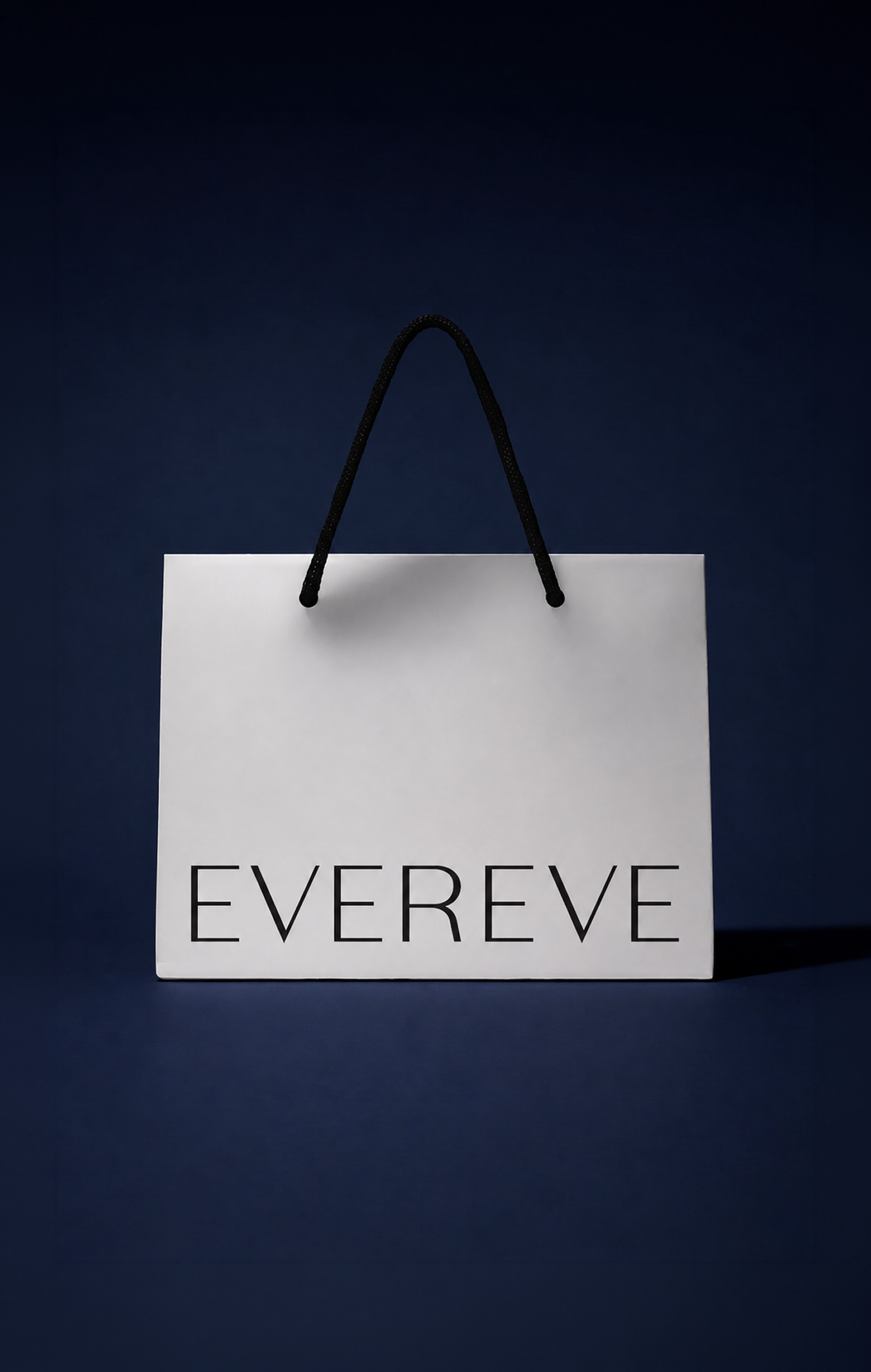 A white shopping bag with black handles and the word 'EVERY' printed on it in black letters, set against a dark blue background.