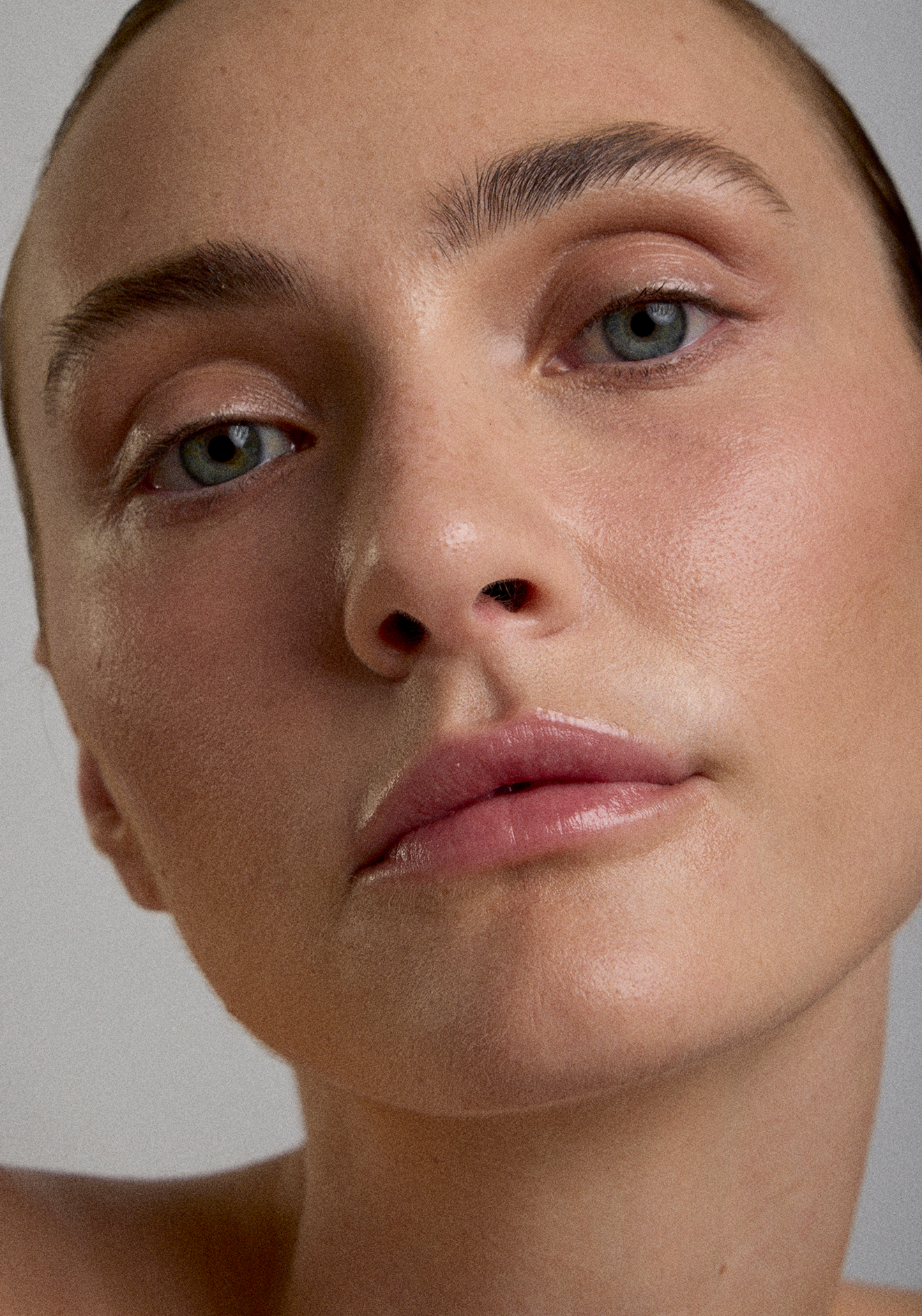 Close-up of a woman's face showing her eyes, nose, and lips, with smooth skin and natural makeup.