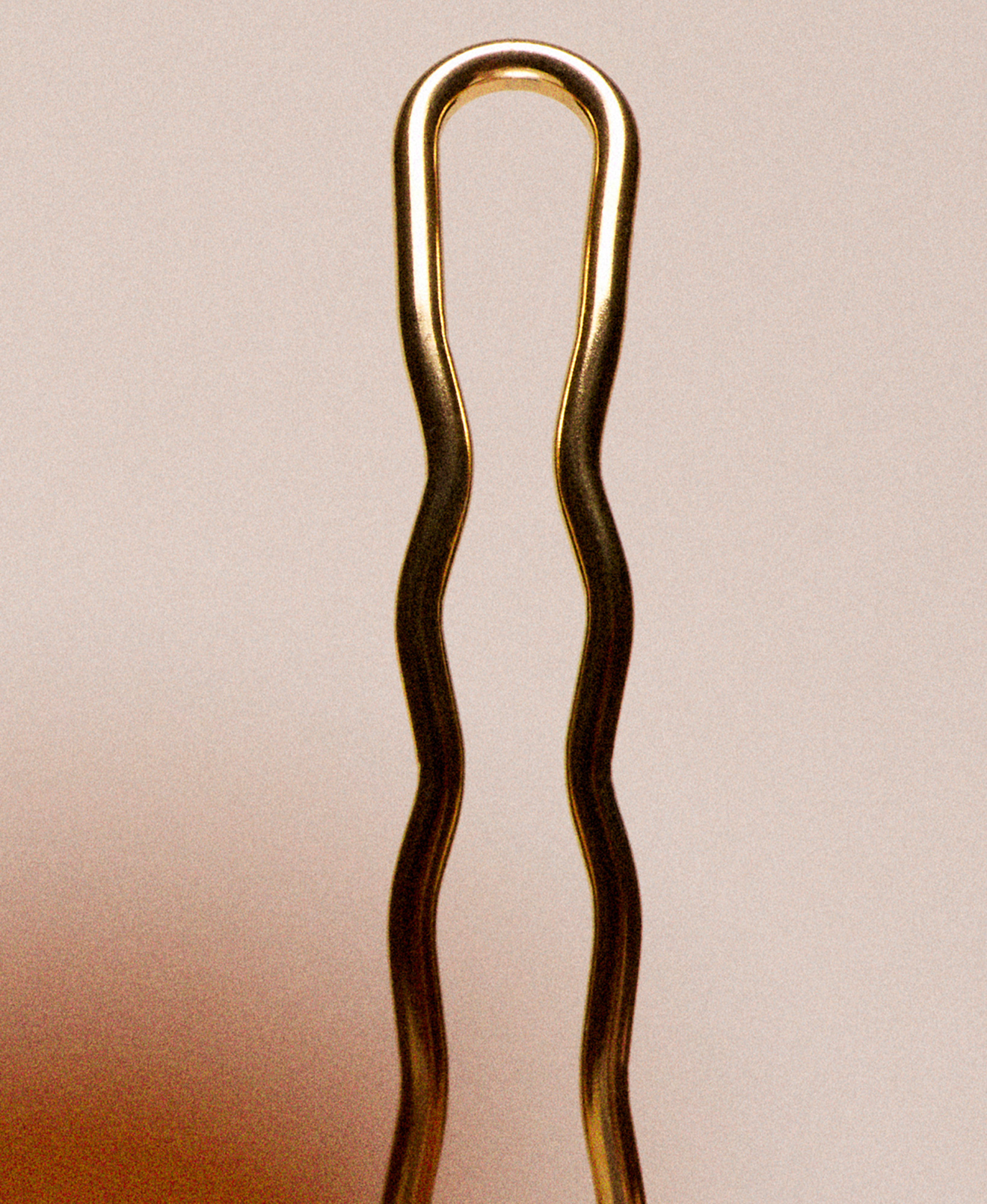 Close-up of a metallic hairpin with a wavy design.