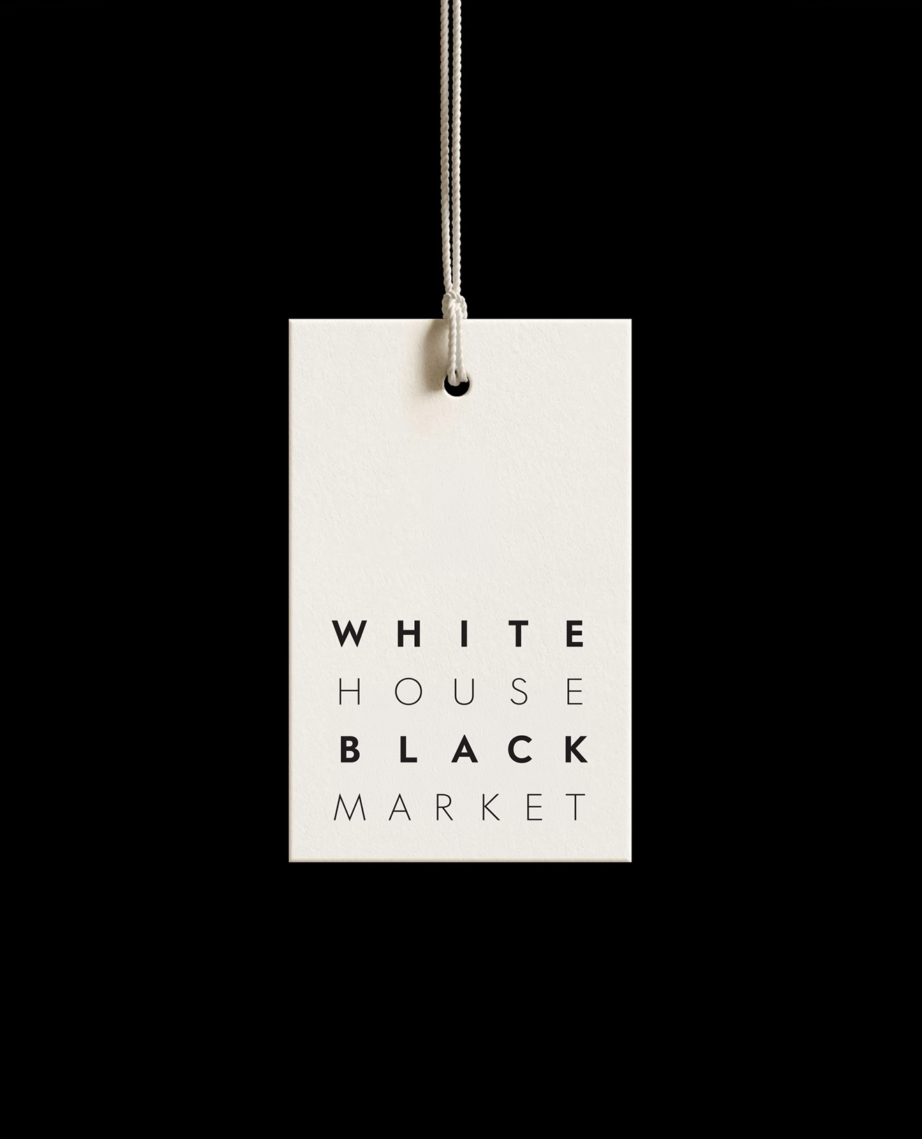 White price tag with black text reading "White House Black Market" hanging from a white string against a black background.