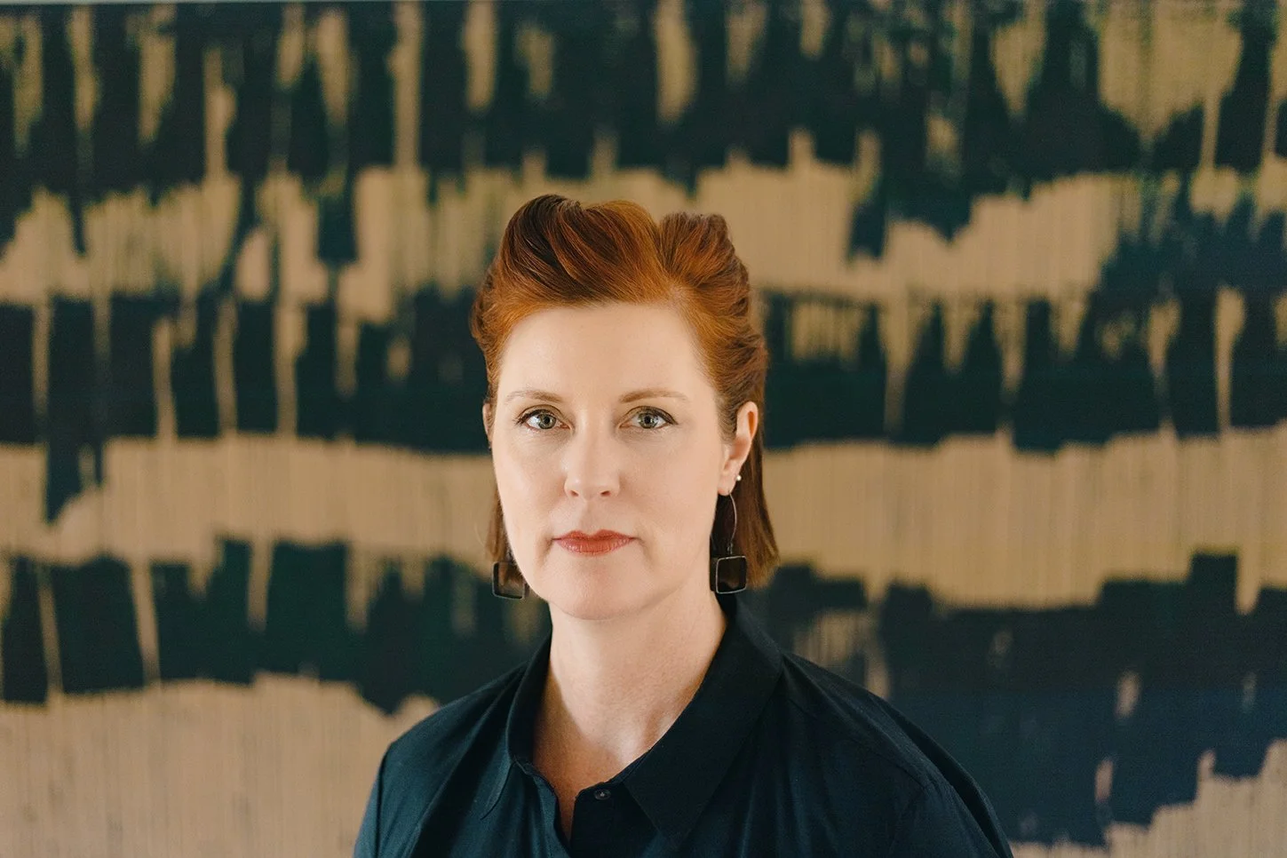 Addie Langford, Associate Director, DDD Detroit Independent Study Program, Director of the DDD Art + Pedagogy Lab, and Interim Director of the DDD ISP Program in Studio + Post-Studio, standing in front of her own artwork.