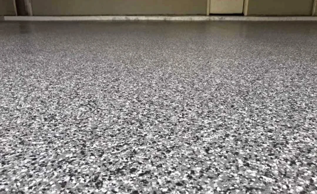 Close-up of a speckled gray and black epoxy flooring.