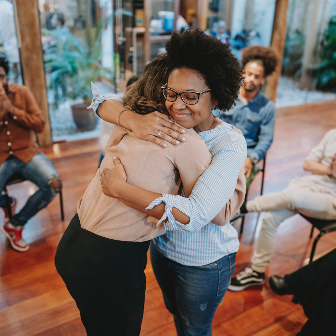 people hugging in grief support group