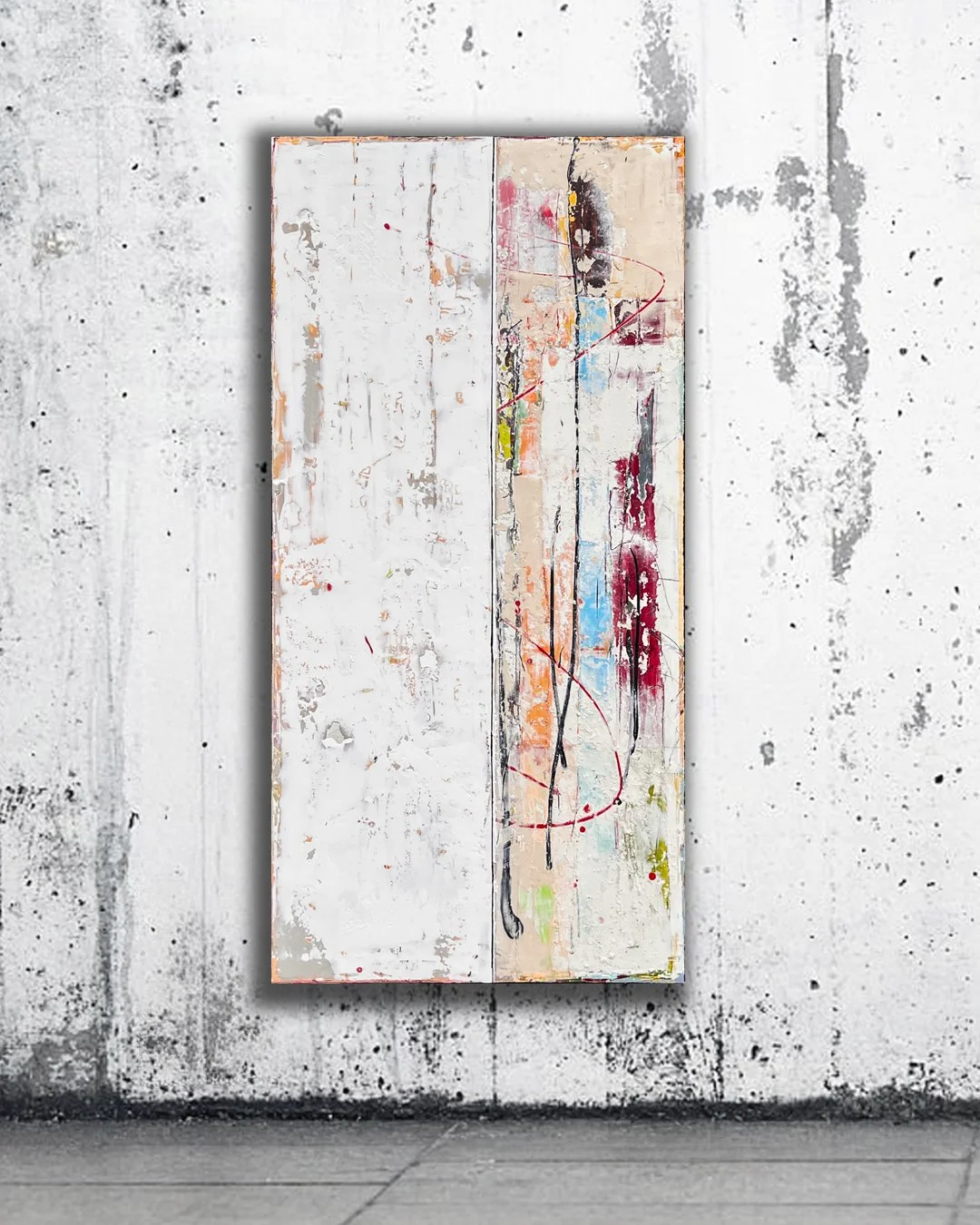 Abstract multicolored painting hanging on a distressed white wall.