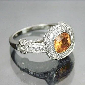 Orange cushion-shaped center stone in a clear-stone halo with accented split shoulders.