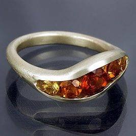 Gold-tone wave-shaped band with a channel of yellow, orange and reddish stones.