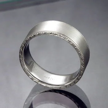 Wide silver-tone band with a brushed center and engraved leaf-like edges.