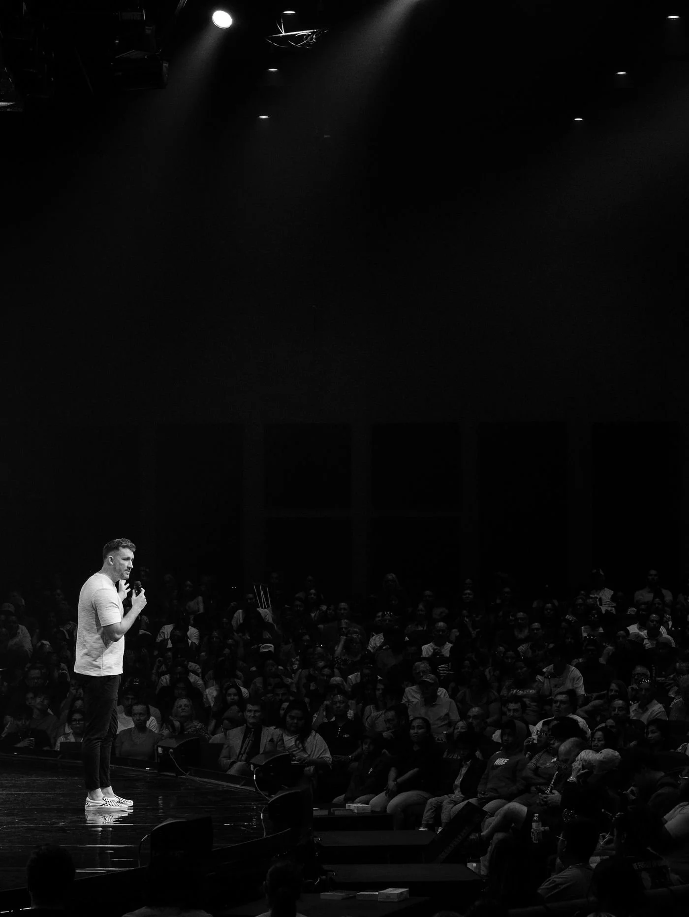 Pastor speaking on stage in a spotlight