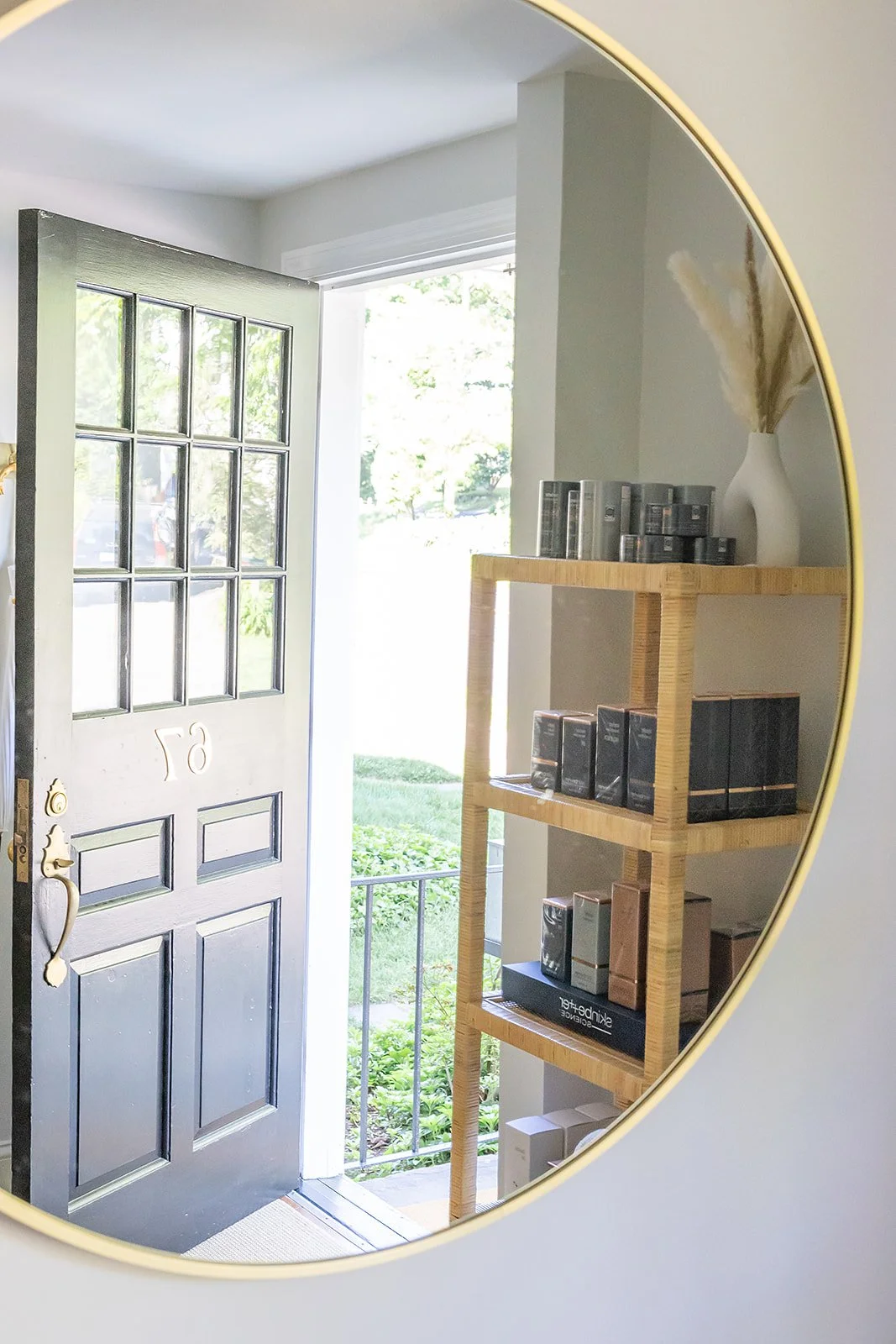 View of the open front door of a med spa, along with a shelf stocked with medical grade skincare products.
