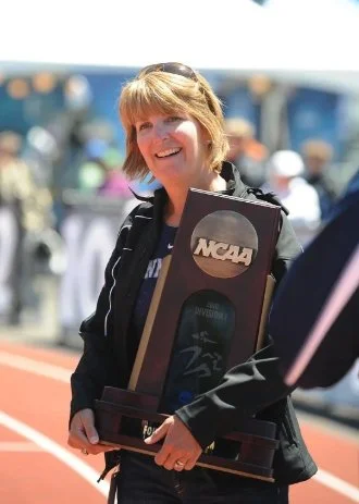 Beth Alford-Sullivan holding an NCAA championship trophy
