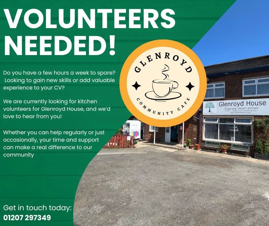 A flyer for volunteers at Glenroyd House Community Cafe featuring a green background, white and yellow text, a logo of a steaming coffee cup, and a photograph of the cafe building with a sign and window displays.