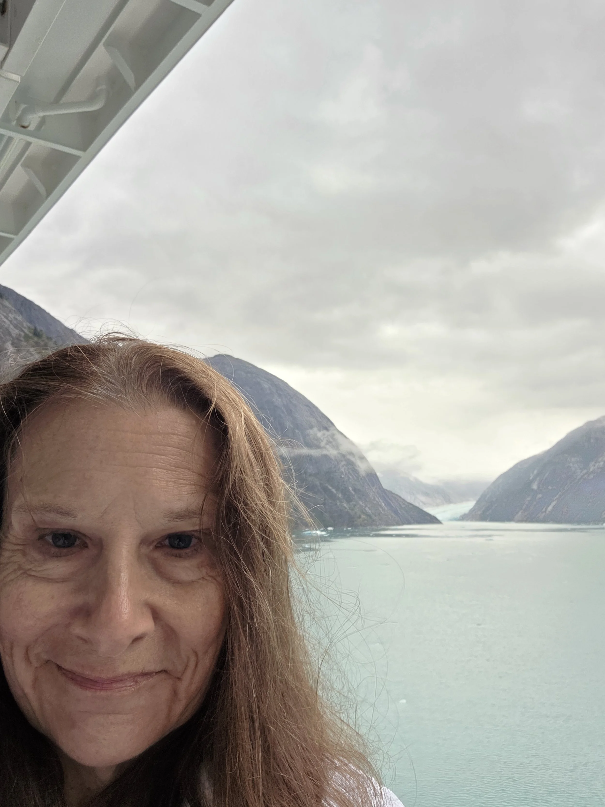 Pascale Smith overlooking a tidewater glacier during an Alaska cruise while researching experiences for future travelers.
