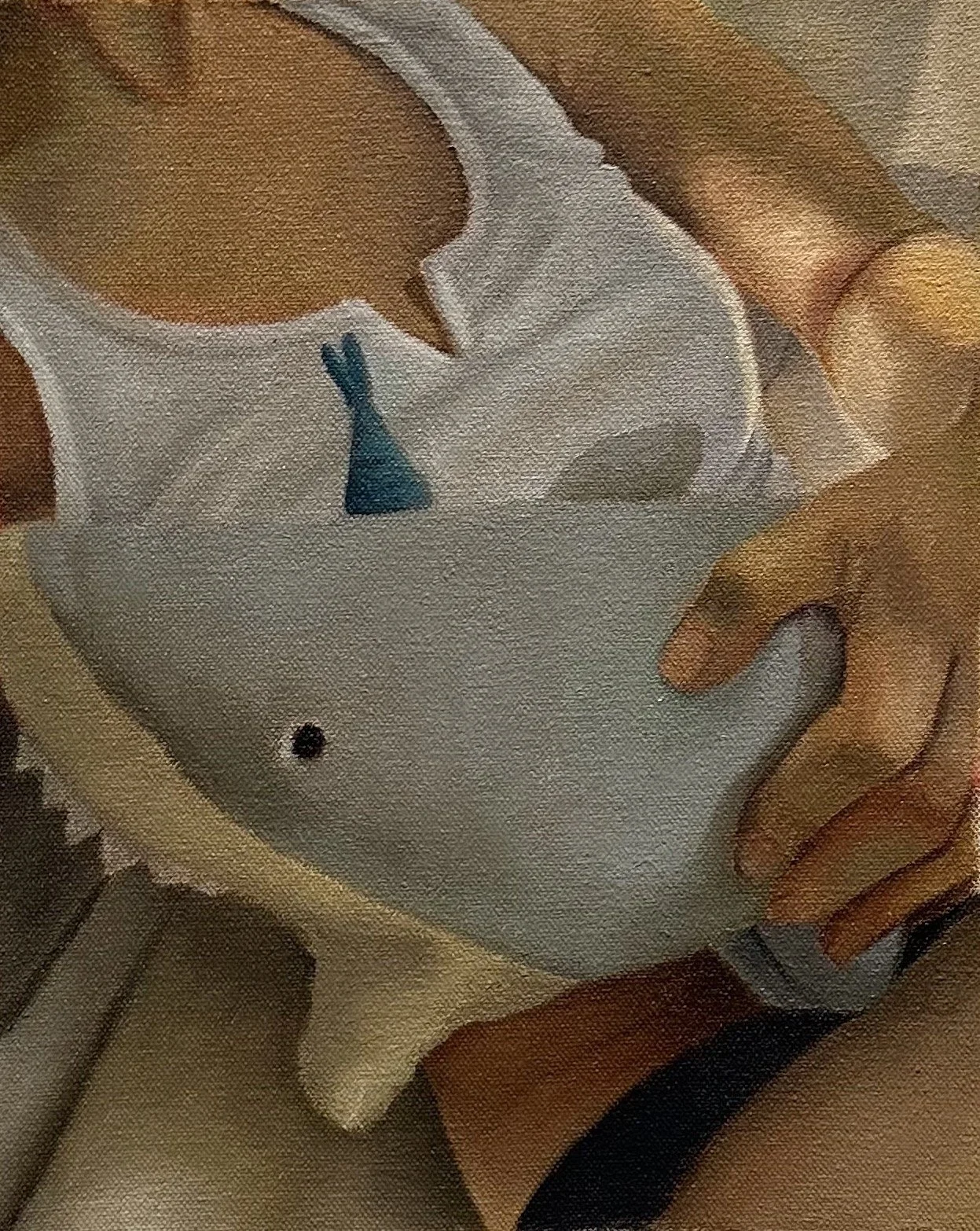 A person holding a shark stuffed animal that wears a party hat.