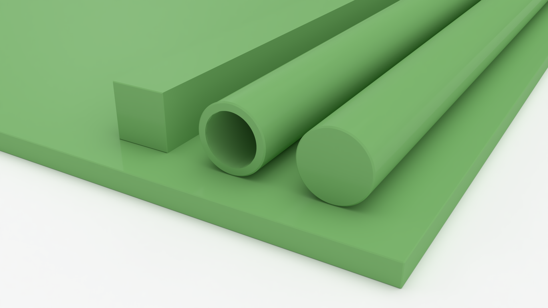 Material plástico de color verde, incluyendo una hoja, una pieza rectangular, un tubo hueco y un cilindro sólido, dispuestos sobre una superficie
