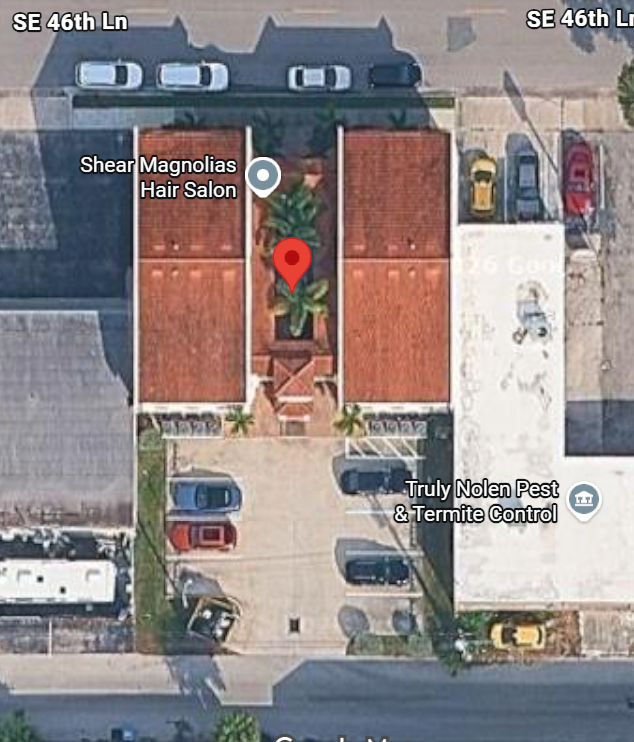 Aerial view of office building. At the top, street parking is visible in front of the building. At the bottom, parking lot for handicap access is visible in back of the building.