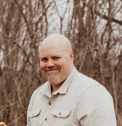 Jeff Wooldridge smiling outdoors in front of trees.