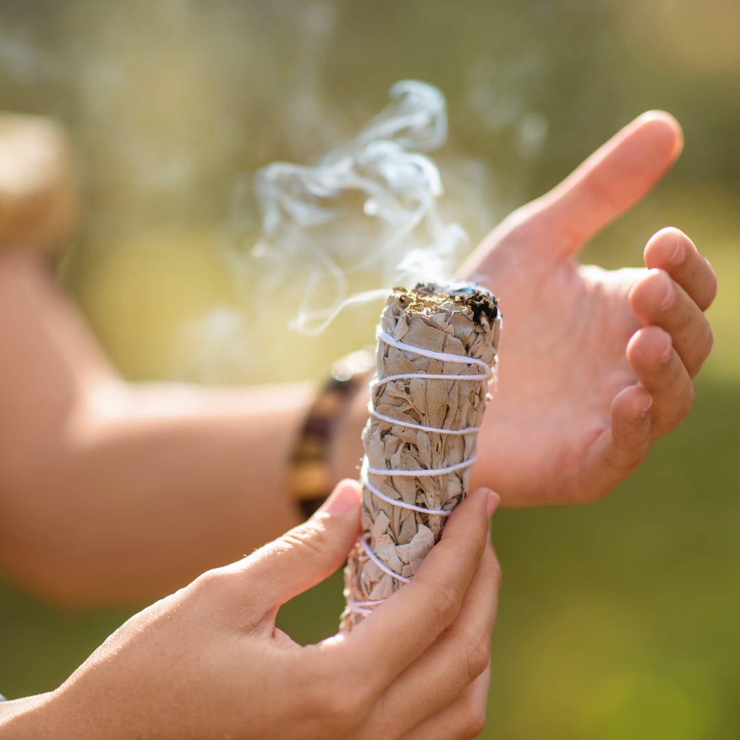 Hands holding smoking sage