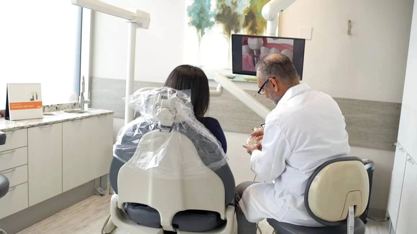 Dentist showing dental model to a patient in a dental office.