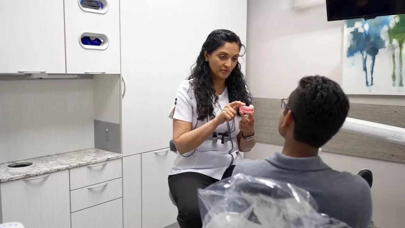 Dentist showing dental model to a patient in a dentist's office.