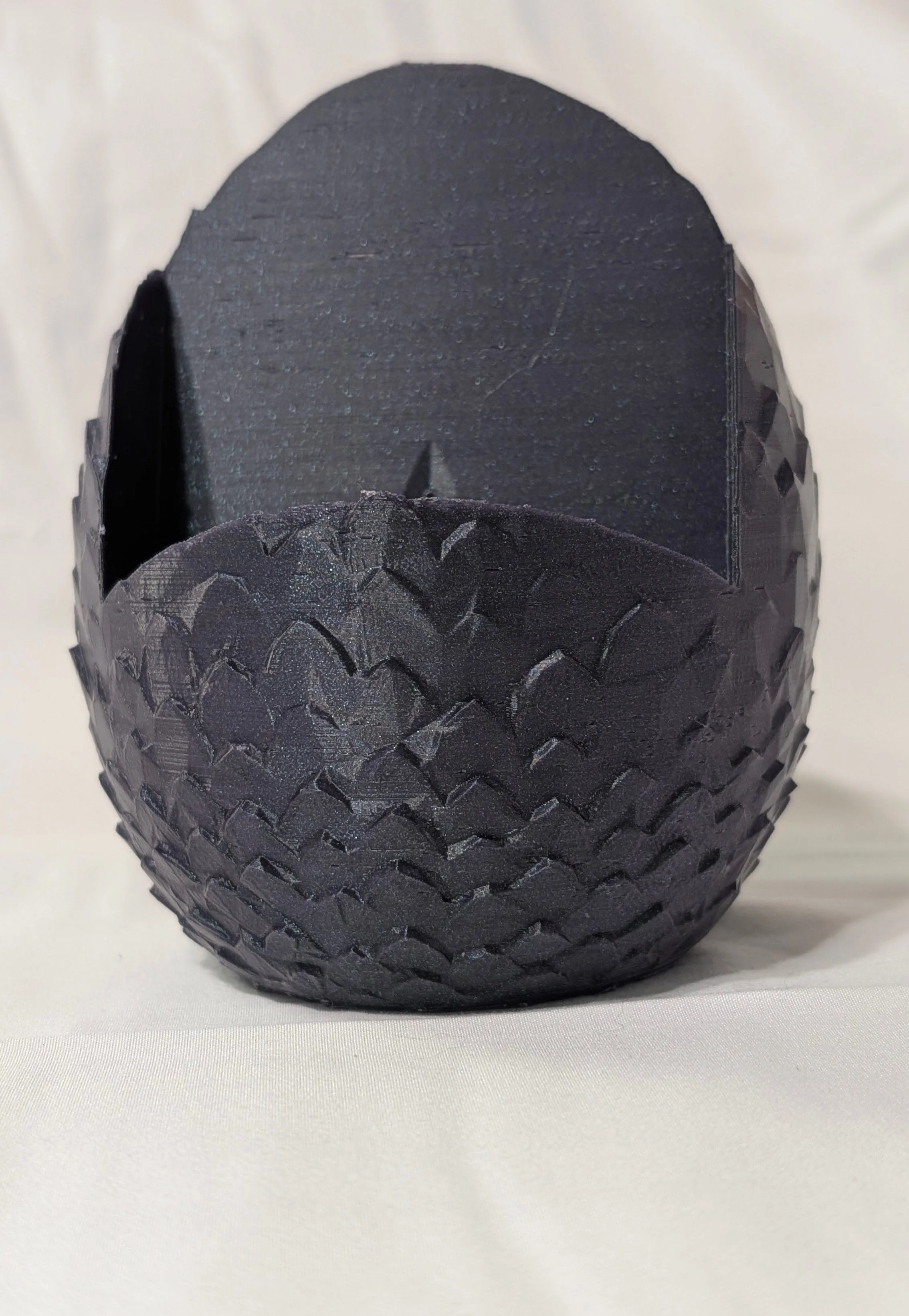 Close-up of a black hockey puck with a textured surface, resting on a white surface with a white background.