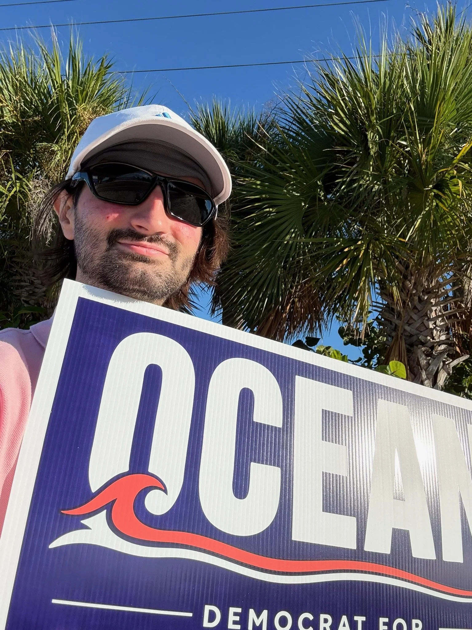 Ocean Fitts holding his Democrat for Florida House 71 campaign sign