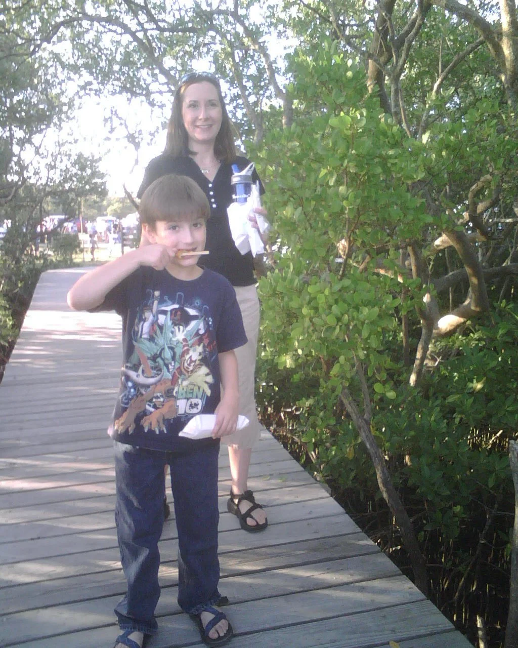 Young Ocean Fitts with his mother on a boardwalk through the mangroves