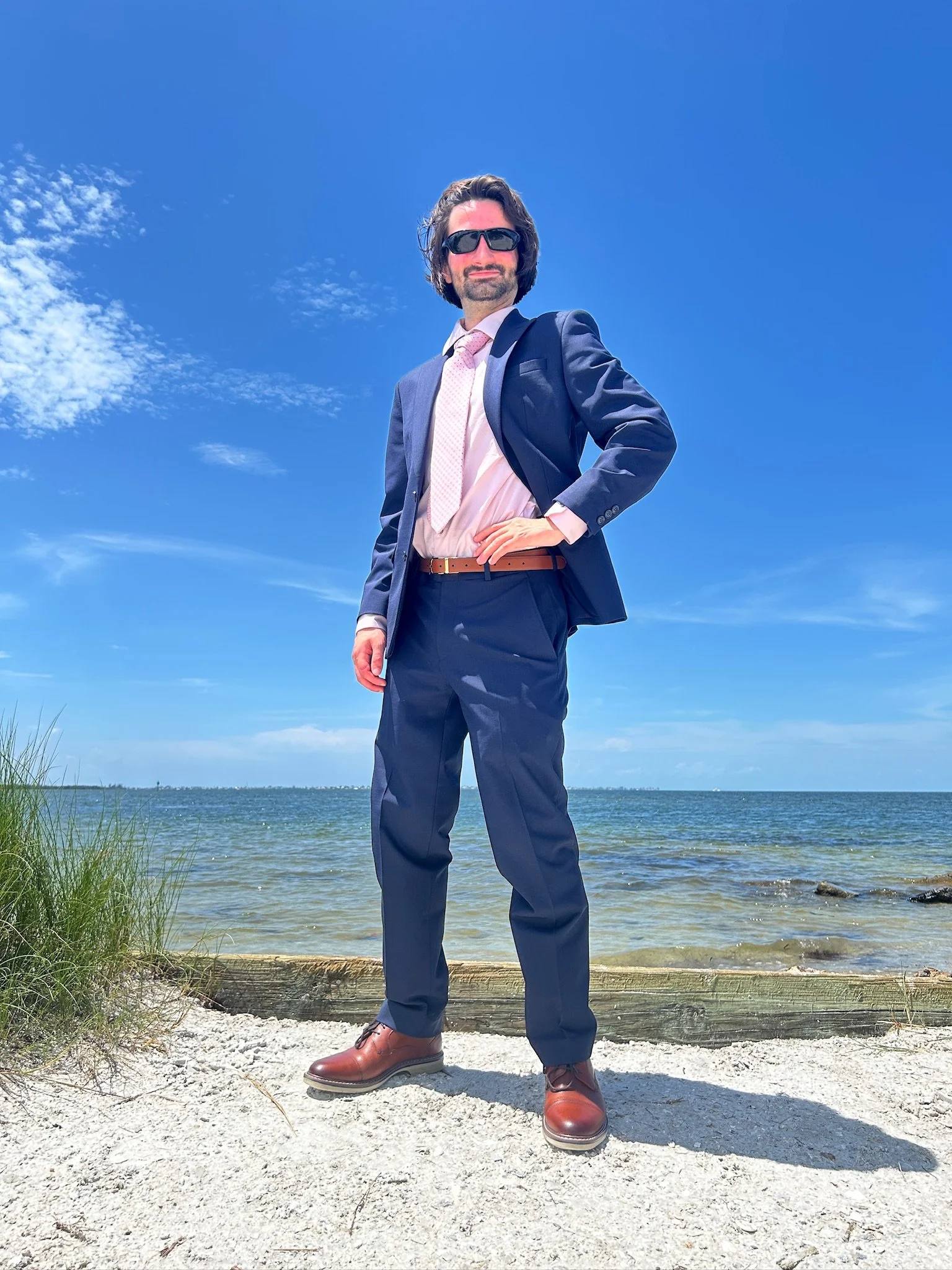 Ocean Fitts, Democratic candidate for Florida House District 71, standing by the water in a navy suit
