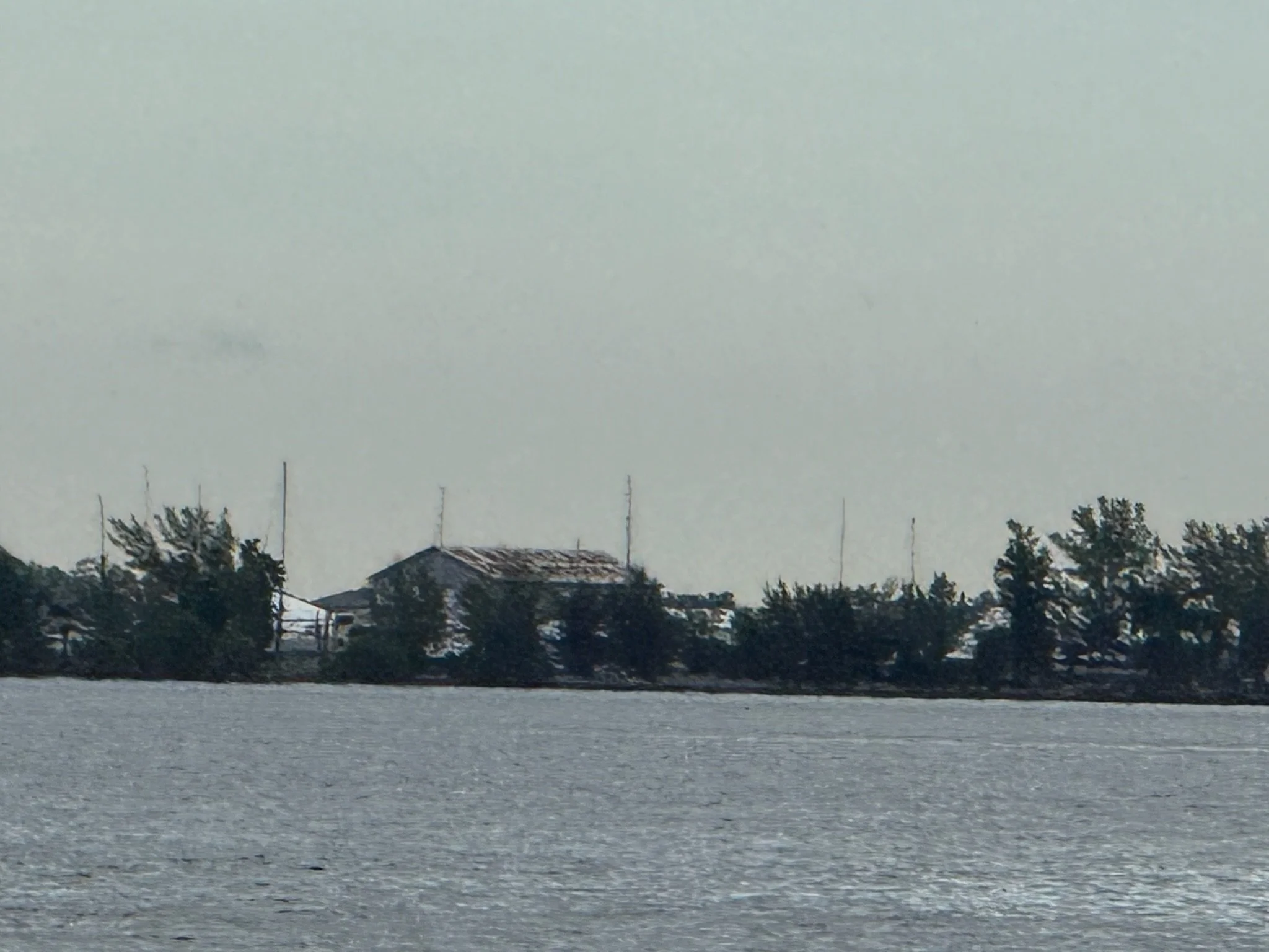 Waterfront building with a damaged roof across the bay in Manatee County