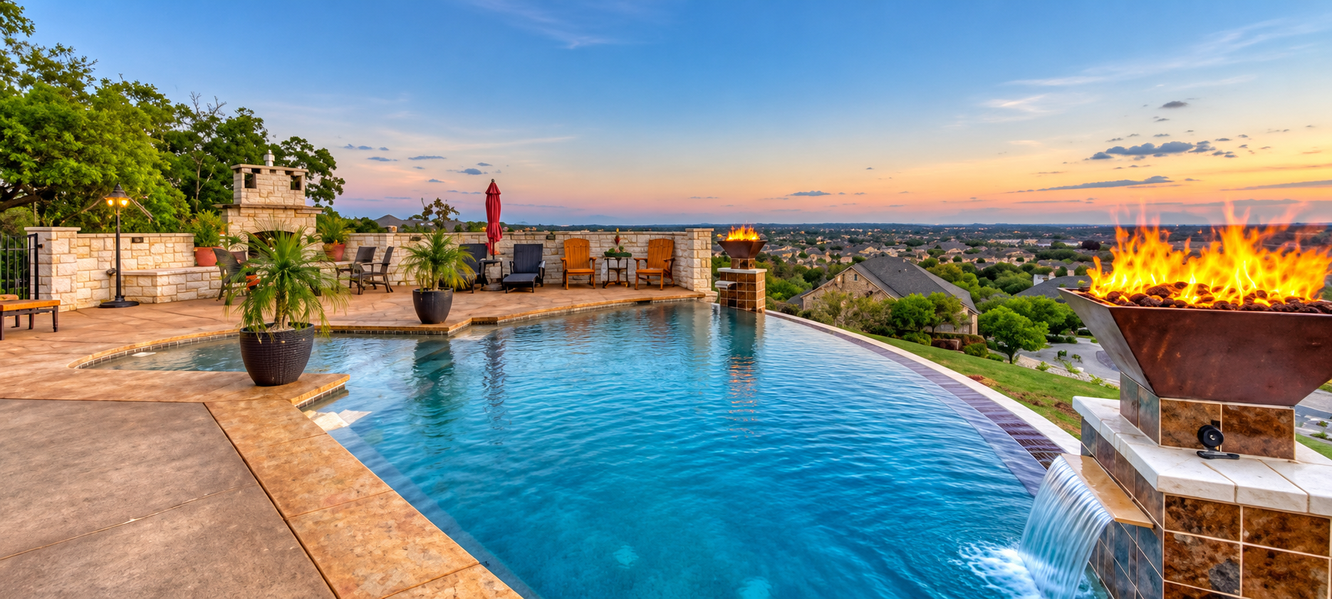 A rooftop swimming pool at sunset with fire pits, lounge chairs, potted plants, and a view of a suburban neighborhood with trees and houses in the distance. A pool that was built by Owner Lee Chapa by Manifest Pools in the Central Texas area