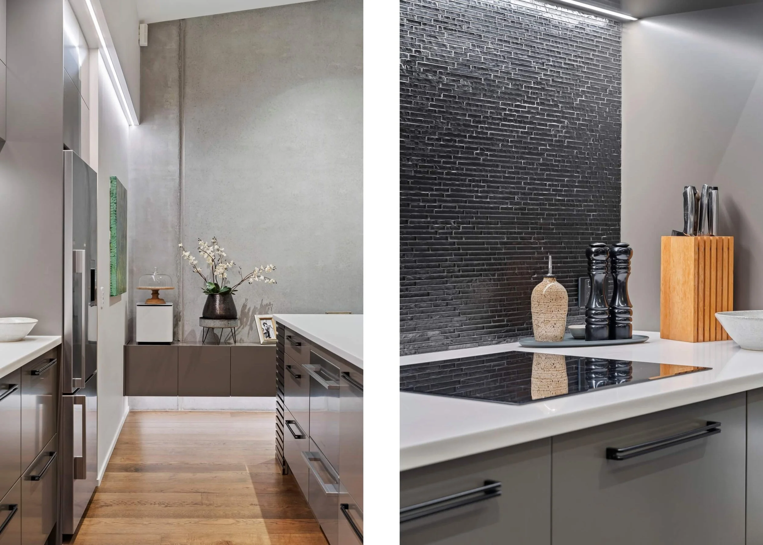 A modern kitchen with contrasting wall textures: smooth concrete on the left and a black brick wall on the right. The kitchen has white countertops, gray cabinetry, and decorative objects including vases and a wooden knife block.