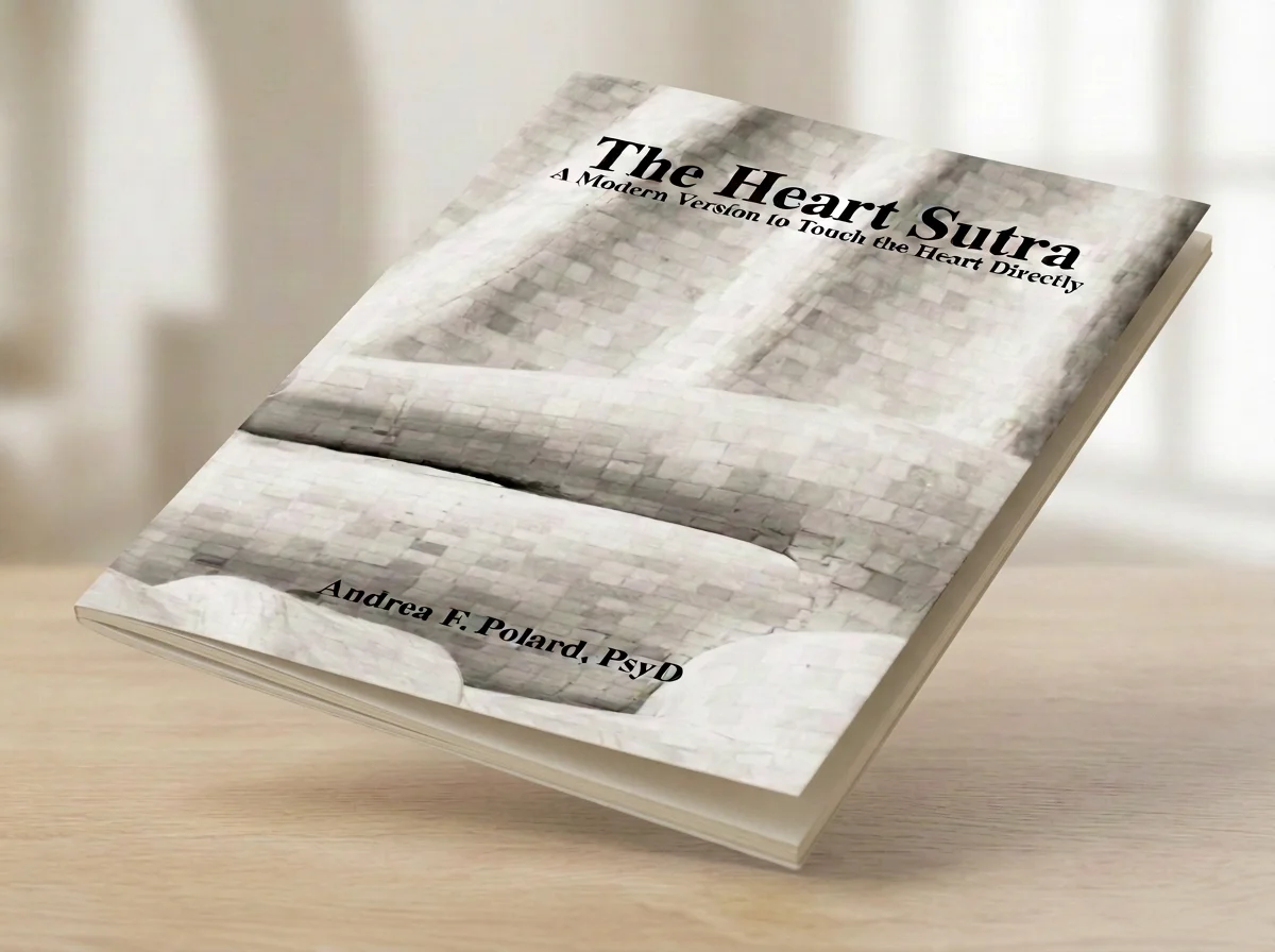 Book titled “The Heart Sutra: A Modern Version to Touch the Heart Directly” by Andrea F. Poland, PsyD, resting on a wooden table.