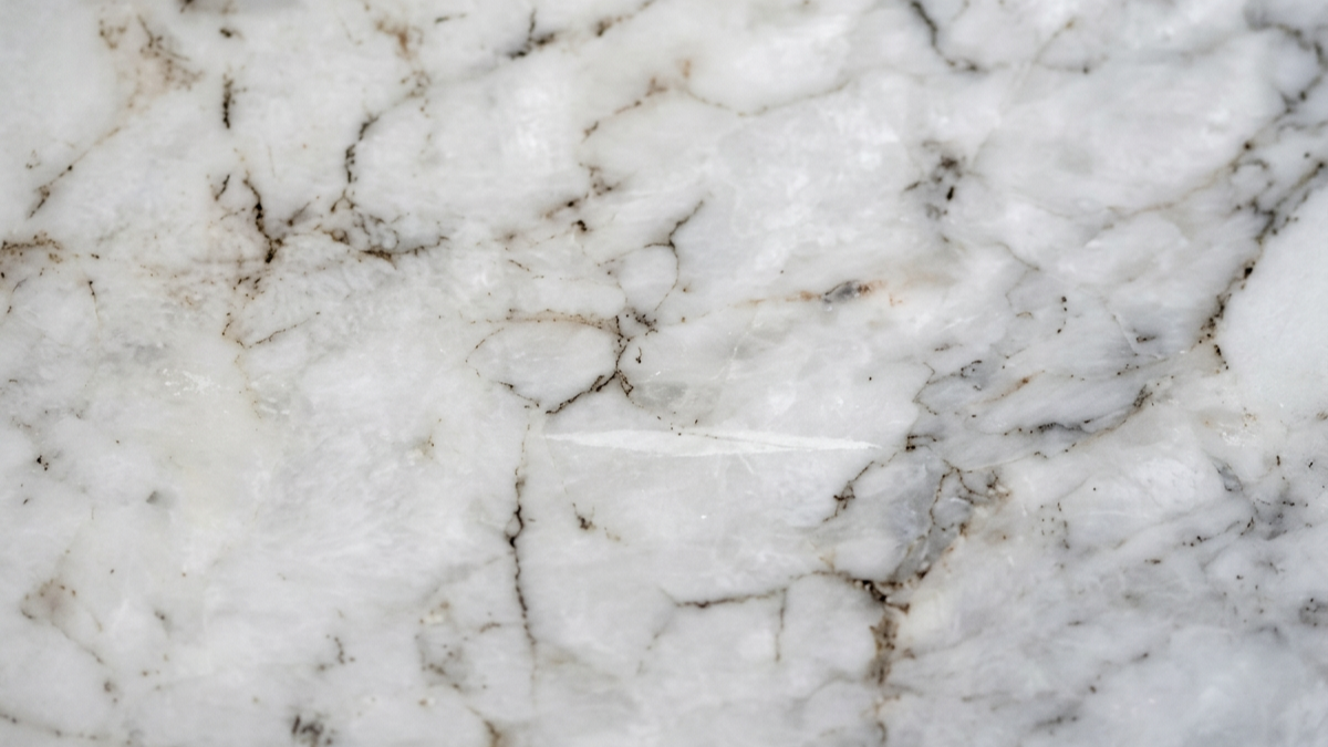 Close-up of white marble with gray and brown veining.