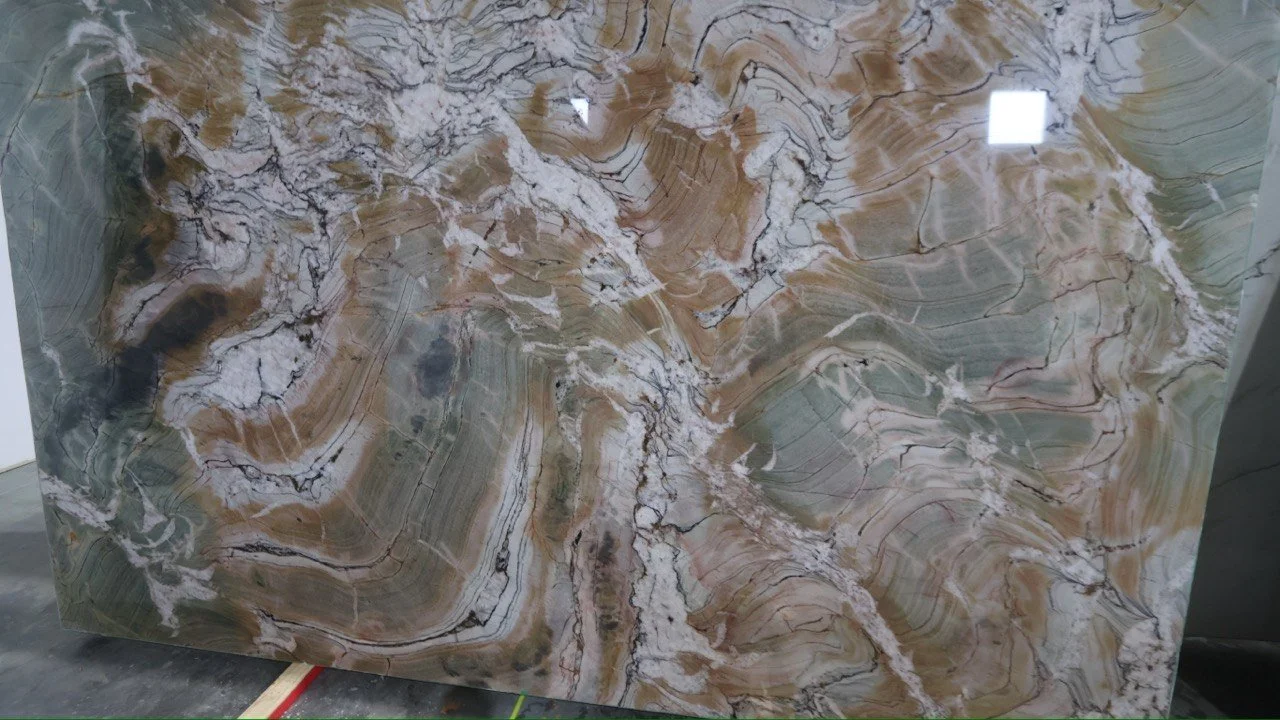A large polished stone slab with swirling patterns of brown, beige, white, and black veins.