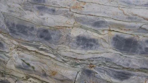 Close-up of a marble surface with gray, beige, and dark veins.