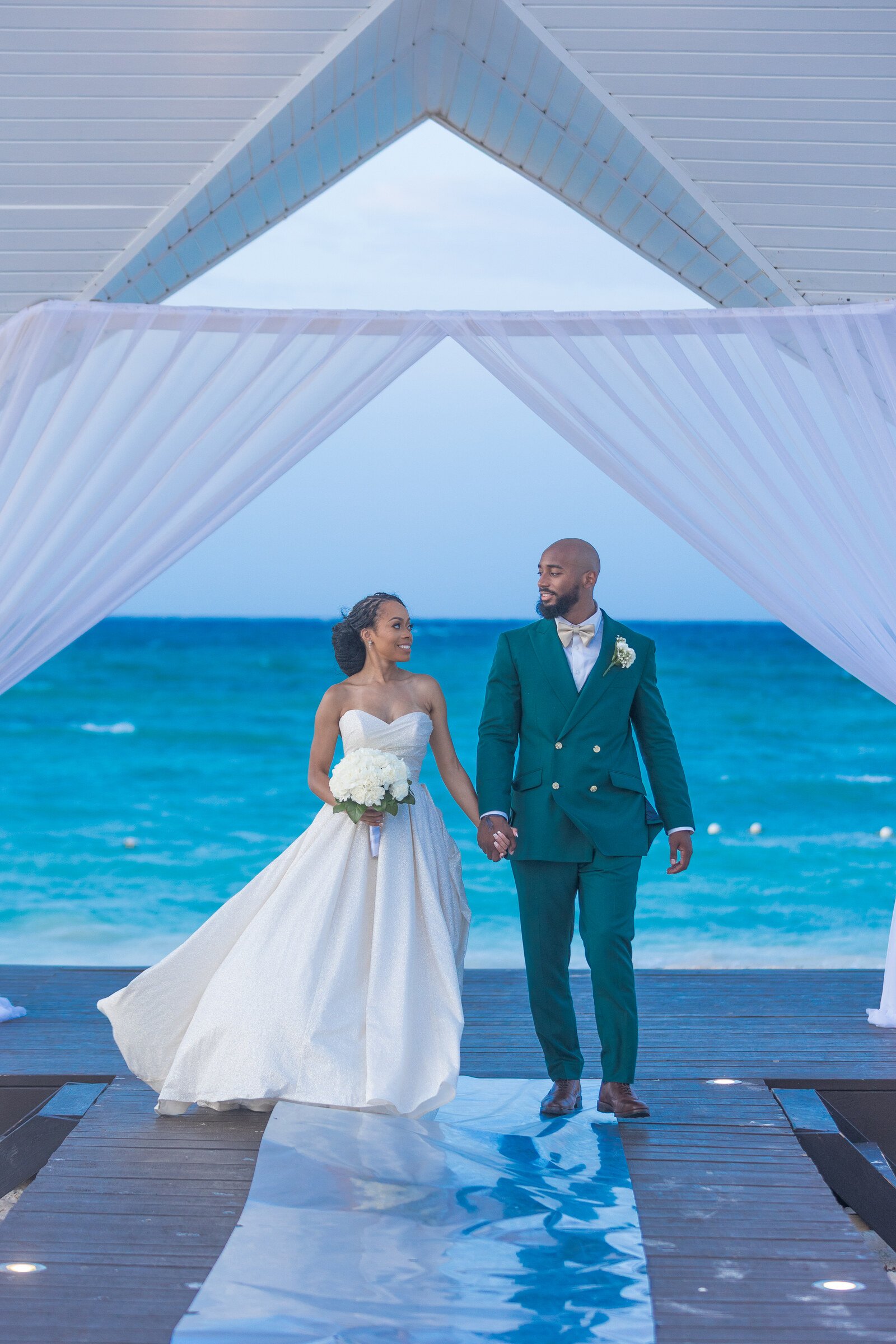 Ashley and Jahron walking beneath resort architecture in Montego Bay