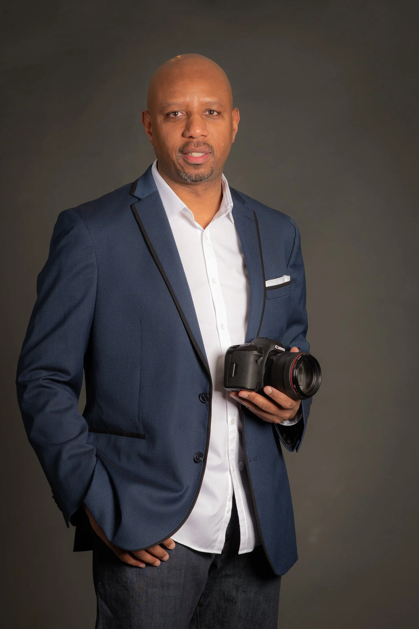 Tierre holding a camera in a portrait for Anaya Photo & Film