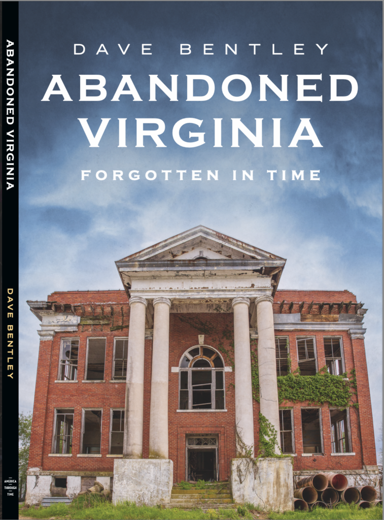An abandoned, old brick building with classical columns and an overgrown facade, illustrating decay.