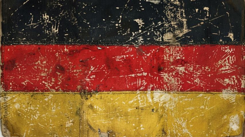 A weathered, painted representation of the German flag with black, red, and yellow horizontal stripes.
