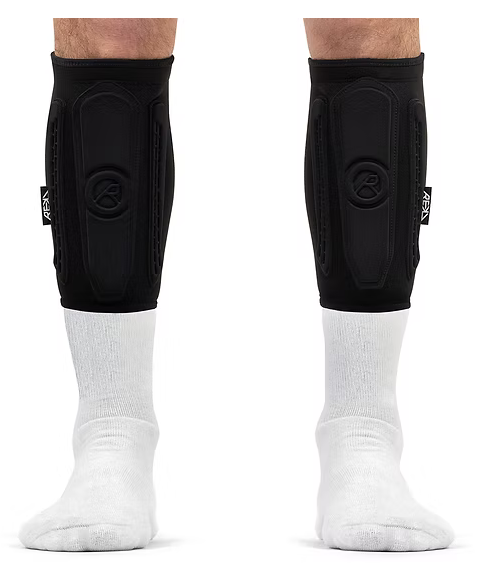 A person's legs wearing black knee or shin compression sleeves and white socks.