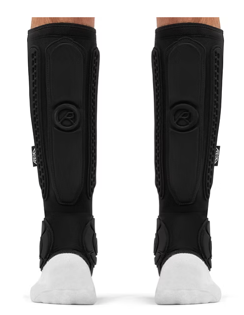 Pair of black athletic leg guards worn on legs with white socks, viewed from front.