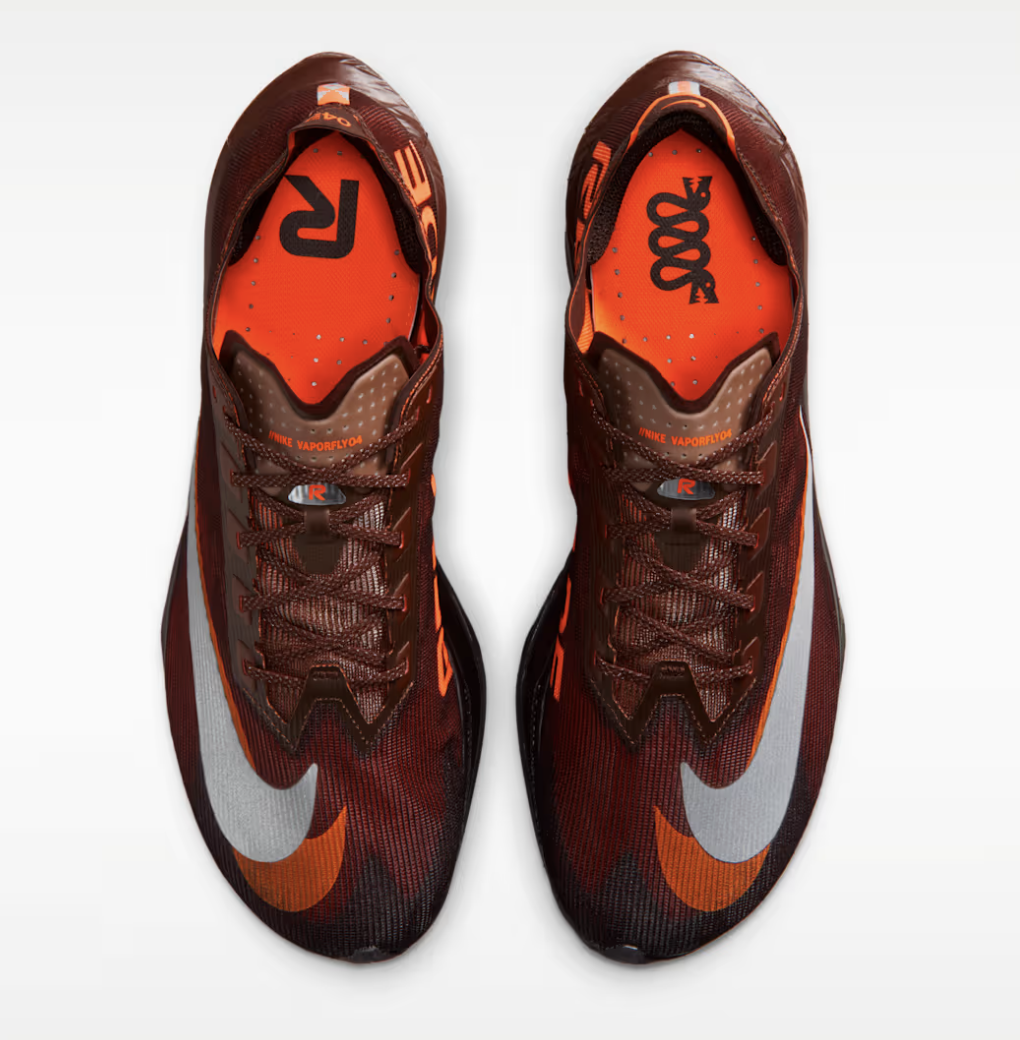 Top view of a pair of red and orange Nike Vaporfly 4 marathon shoes with black and gray accents, Nike swoosh logos, and orange insoles.