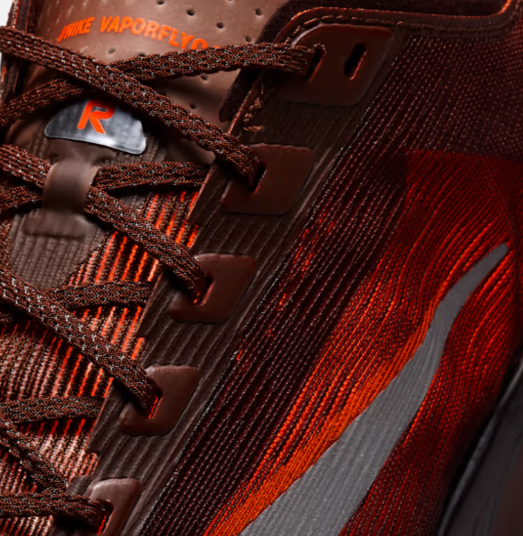 Close-up of a Nike Vaporfly running shoe in red and black with detailed stitching and laces.