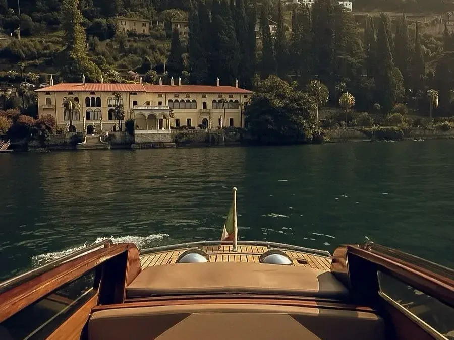 Luxury boat heading towards lakeside villa