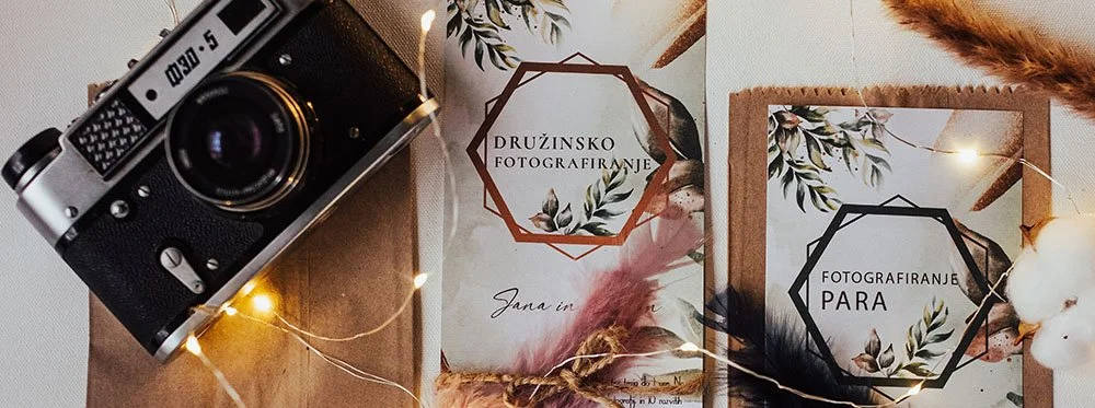 Photography camera, wedding photography flyers, dried flowers, and string lights.