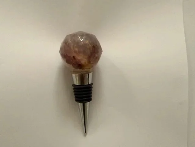 Handmade resin wine stopper with a real purple strawflower preserved in a faceted resin top with a soft cloudy finish.