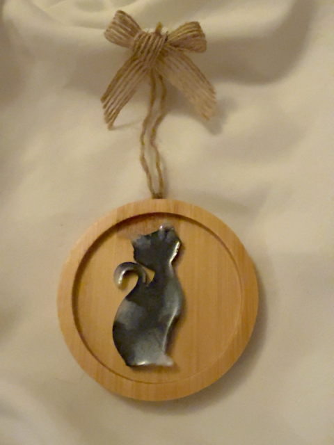 Handmade black and white resin sitting cat Christmas decoration on a 6.5 cm round wooden ornament, finished with natural jute hanging twine and a rustic hessian bow.